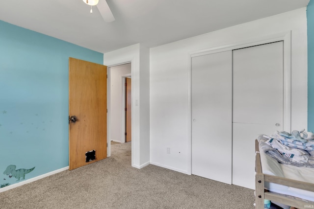 bedroom with a closet, baseboards, a ceiling fan, and carpet