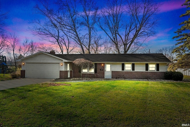 ranch-style home featuring a garage, concrete driveway, a front lawn, and brick siding