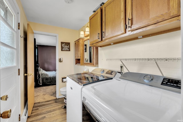 laundry room featuring light wood finished floors and washing machine and clothes dryer
