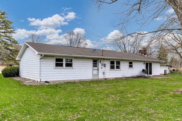 back of house with a chimney and a lawn