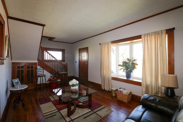 living room featuring hardwood / wood-style floors, ornamental molding, and stairway