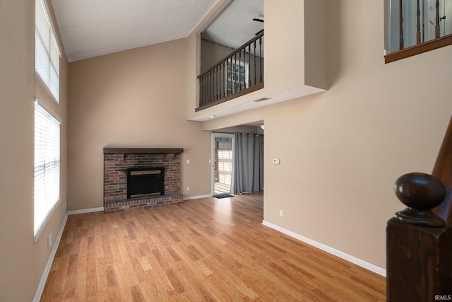 526 Cambridge Dr, Kokomo, IN 46902 - unfurnished living room with a fireplace, visible vents, a high ceiling, wood finished floors, and baseboards