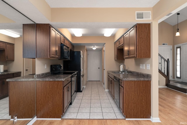 526 Cambridge Dr, Kokomo, IN 46902 - kitchen with black microwave, visible vents, dark countertops, a sink, and range with electric cooktop