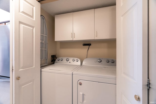 526 Cambridge Dr, Kokomo, IN 46902 - clothes washing area with washer and dryer, a textured ceiling, and cabinet space