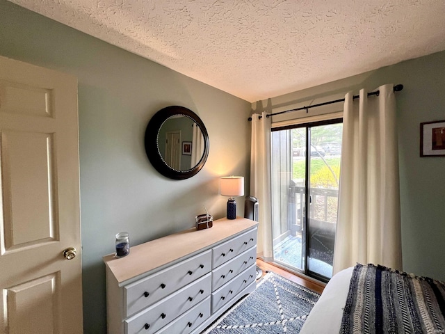 bedroom featuring access to exterior and a textured ceiling