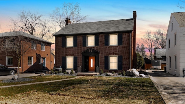 4707 Old Mill Rd, Fort Wayne, IN 46807 - colonial house featuring roof with shingles, a chimney, and brick siding