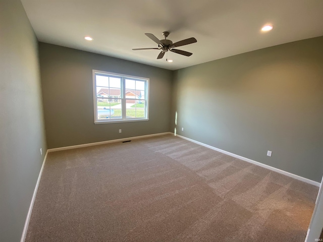spare room featuring light colored carpet, ceiling fan, baseboards, and recessed lighting