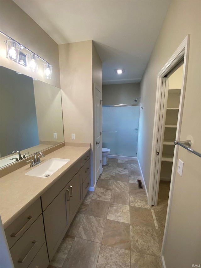 bathroom with visible vents, baseboards, toilet, a shower, and vanity