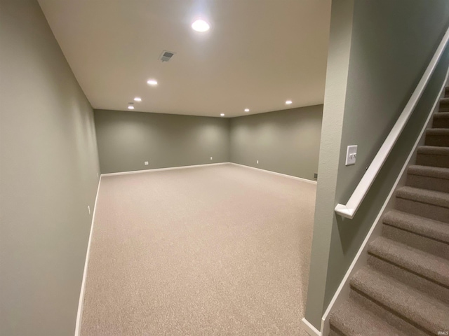 finished below grade area featuring visible vents, baseboards, carpet floors, recessed lighting, and stairs