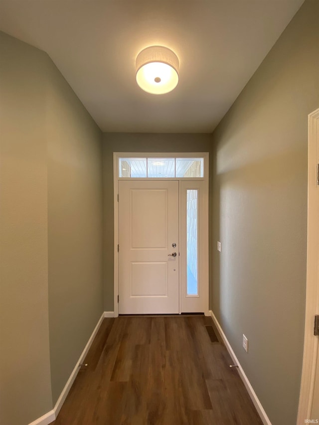 foyer with dark wood-style flooring, baseboards, and vaulted ceiling