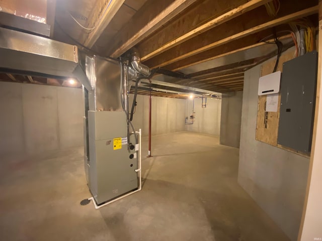 unfinished basement featuring electric panel and heating unit