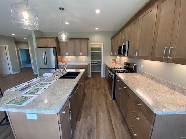 kitchen featuring a sink, dark wood-style floors, recessed lighting, a center island with sink, and stainless steel appliances