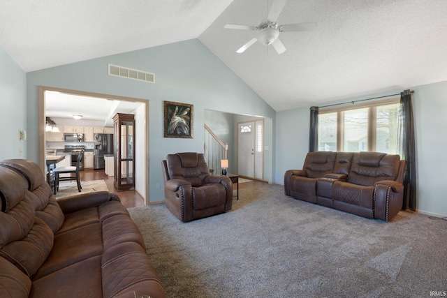 living room with stairway, visible vents, ceiling fan, light colored carpet, and high vaulted ceiling