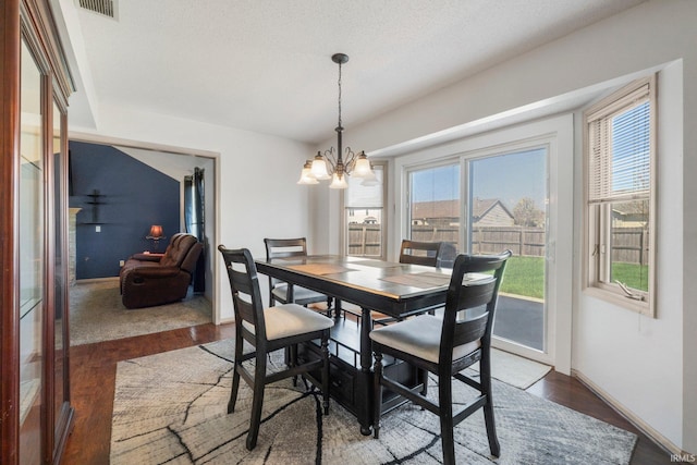 dining room featuring a notable chandelier, wood finished floors, and baseboards