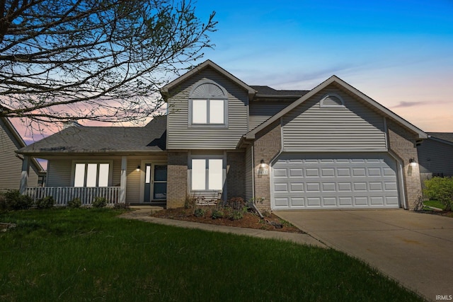 traditional home featuring concrete driveway, covered porch, a lawn, brick siding, and a garage