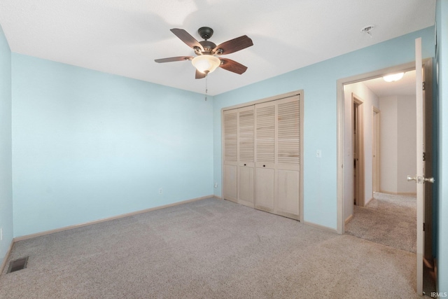 unfurnished bedroom featuring a closet, visible vents, light colored carpet, and baseboards