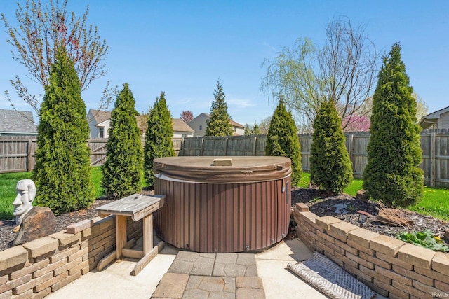 view of patio with a fenced backyard and a hot tub