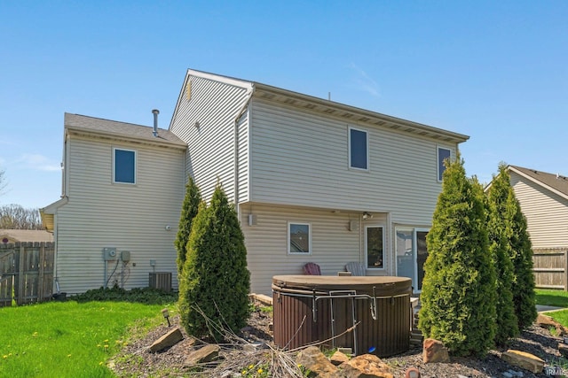 back of house featuring fence and a hot tub