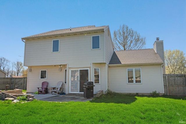 back of property featuring a chimney, a fenced backyard, a yard, and a patio area