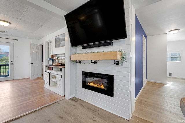 604 Short St, Decatur, IN 46733 - living area with light wood-style flooring, baseboards, a large fireplace, and a drop ceiling