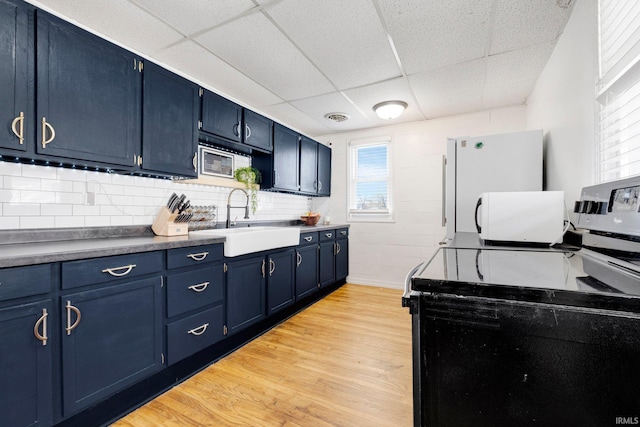 604 Short St, Decatur, IN 46733 - kitchen with a sink, blue cabinets, range with electric cooktop, light wood-style flooring, and a paneled ceiling