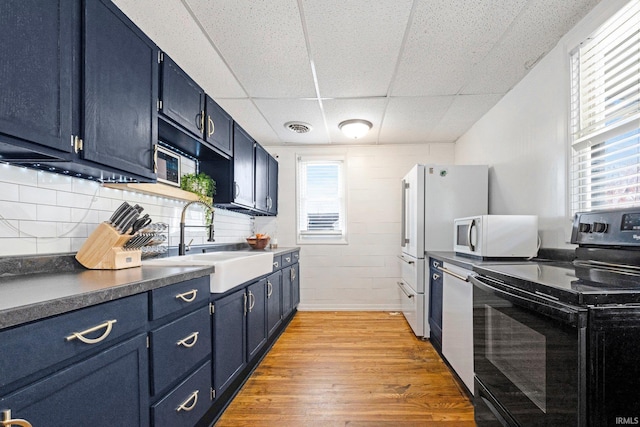 604 Short St, Decatur, IN 46733 - kitchen featuring black / electric stove, blue cabinets, a sink, white microwave, and a paneled ceiling