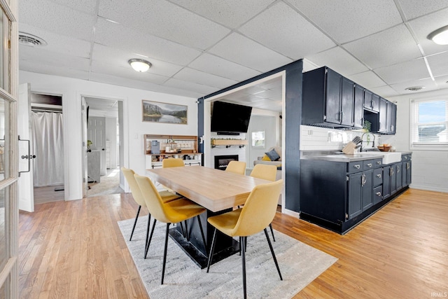 604 Short St, Decatur, IN 46733 - dining space featuring visible vents, a glass covered fireplace, light wood-style floors, and a paneled ceiling