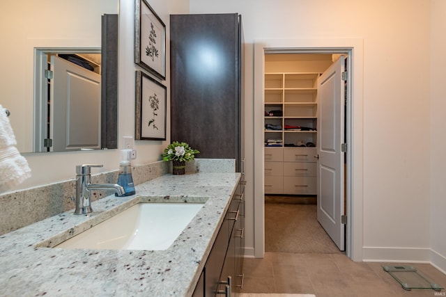 304 W Kirkwood Ave Unit 305, Bloomington, IN 47404 - bathroom featuring tile patterned floors, vanity, baseboards, and a spacious closet