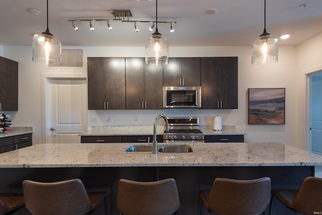 304 W Kirkwood Ave Unit 305, Bloomington, IN 47404 - kitchen featuring dark brown cabinetry, appliances with stainless steel finishes, a sink, and a breakfast bar