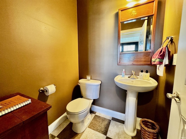 half bath with toilet and baseboards