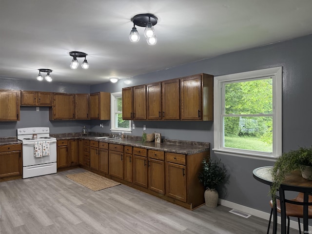 15336 County Farm Rd, Shoals, IN 47581 - kitchen featuring white range with electric cooktop, brown cabinets, dark countertops, and light wood-style floors