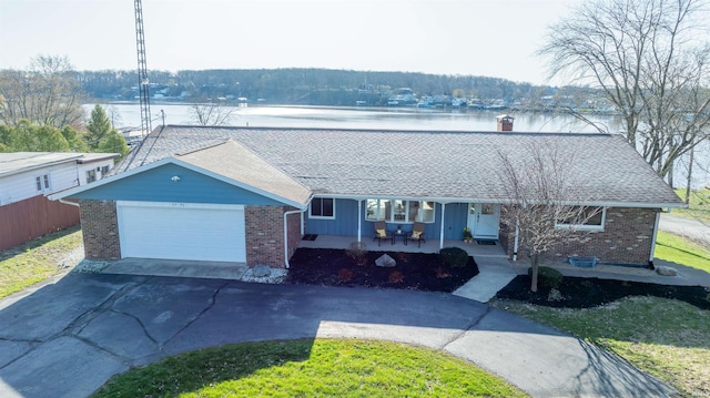 5793 E Pierce Rd, Monticello, IN 47960 - ranch-style house featuring aphalt driveway, covered porch, roof with shingles, brick siding, and a garage