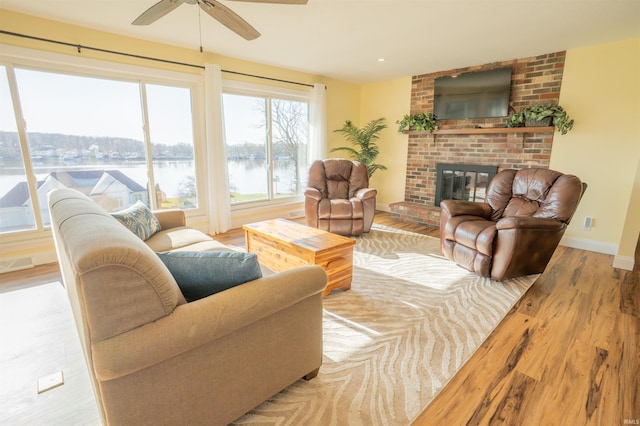 5793 E Pierce Rd, Monticello, IN 47960 - living room featuring visible vents, baseboards, a brick fireplace, a ceiling fan, and wood finished floors