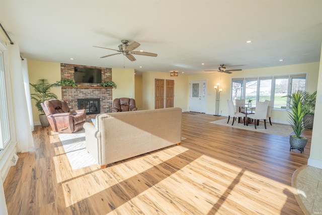 5793 E Pierce Rd, Monticello, IN 47960 - living room featuring wood finished floors, a ceiling fan, a brick fireplace, and recessed lighting