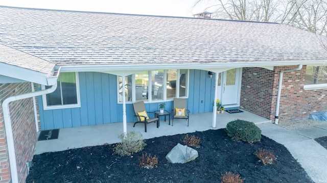 5793 E Pierce Rd, Monticello, IN 47960 - property entrance with a porch, brick siding, board and batten siding, and a shingled roof