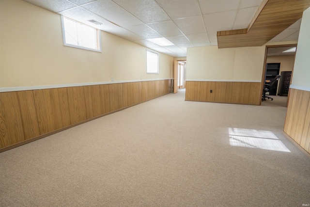 5793 E Pierce Rd, Monticello, IN 47960 - basement featuring a paneled ceiling, carpet flooring, wooden walls, and wainscoting