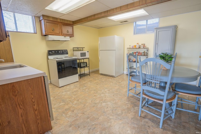 5793 E Pierce Rd, Monticello, IN 47960 - kitchen with a paneled ceiling, white appliances, light countertops, under cabinet range hood, and a sink