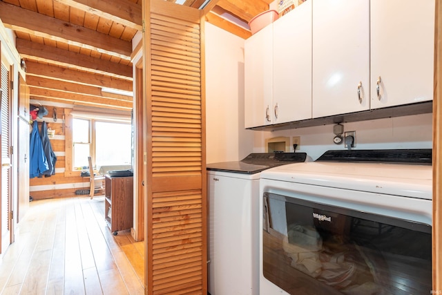 washroom featuring washer and dryer, light wood-style floors, and cabinet space