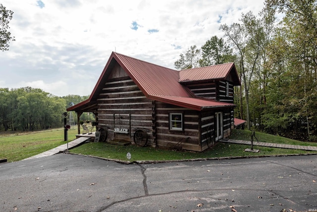 view of side of home featuring a yard and metal roof