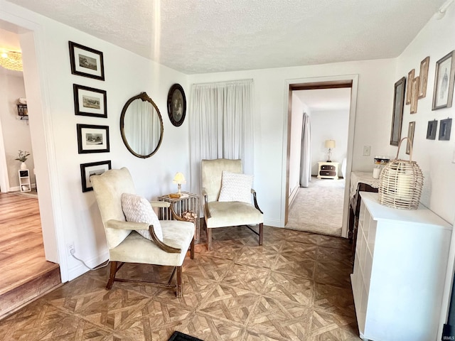 living area featuring a textured ceiling and baseboards