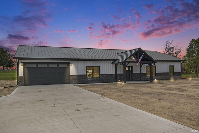 8342 S Sr 17 Hwy, Plymouth, IN 46563 - modern farmhouse featuring an attached garage, stone siding, metal roof, and concrete driveway