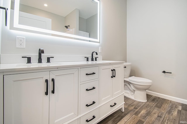8342 S Sr 17 Hwy, Plymouth, IN 46563 - bathroom with baseboards, double vanity, toilet, a sink, and wood finished floors