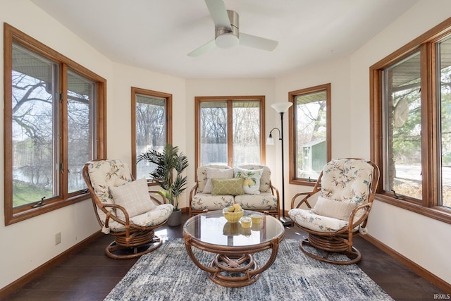 sitting room with a ceiling fan, baseboards, and dark wood finished floors