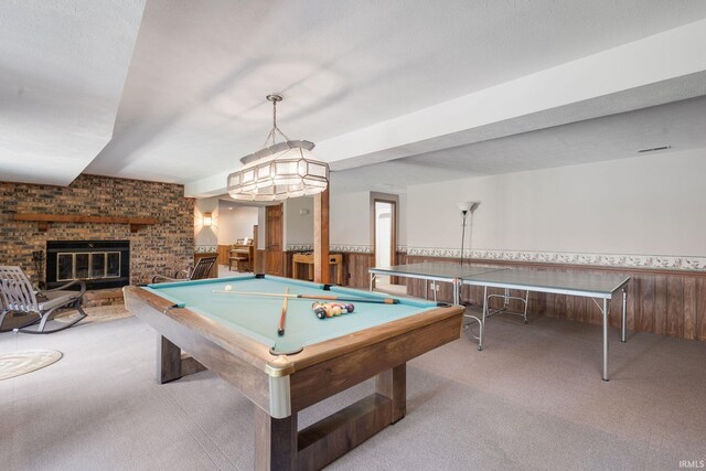 playroom with carpet floors, a wainscoted wall, a brick fireplace, and billiards