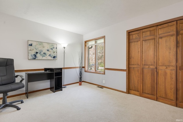 office with visible vents, baseboards, and light colored carpet