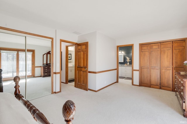unfurnished bedroom with light carpet, ensuite bathroom, and baseboards
