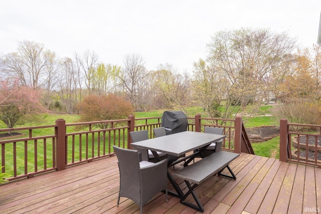 deck with grilling area, outdoor dining space, and a lawn