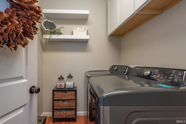 laundry area featuring wood finished floors, washing machine and clothes dryer, baseboards, and cabinet space