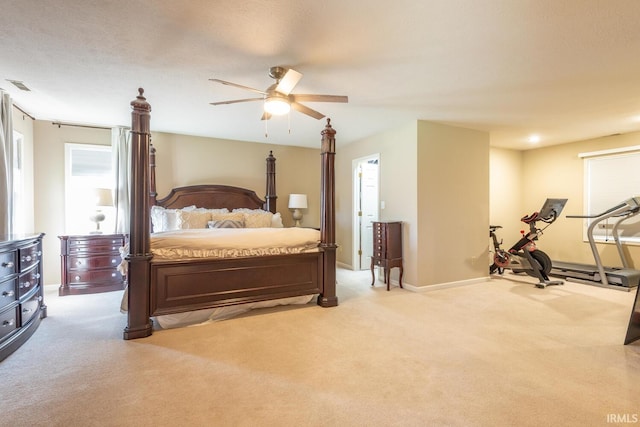 bedroom featuring light carpet, visible vents, baseboards, and a ceiling fan