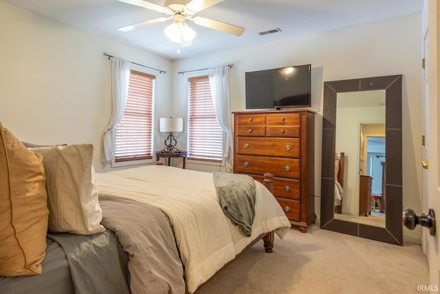 carpeted bedroom featuring ceiling fan and visible vents